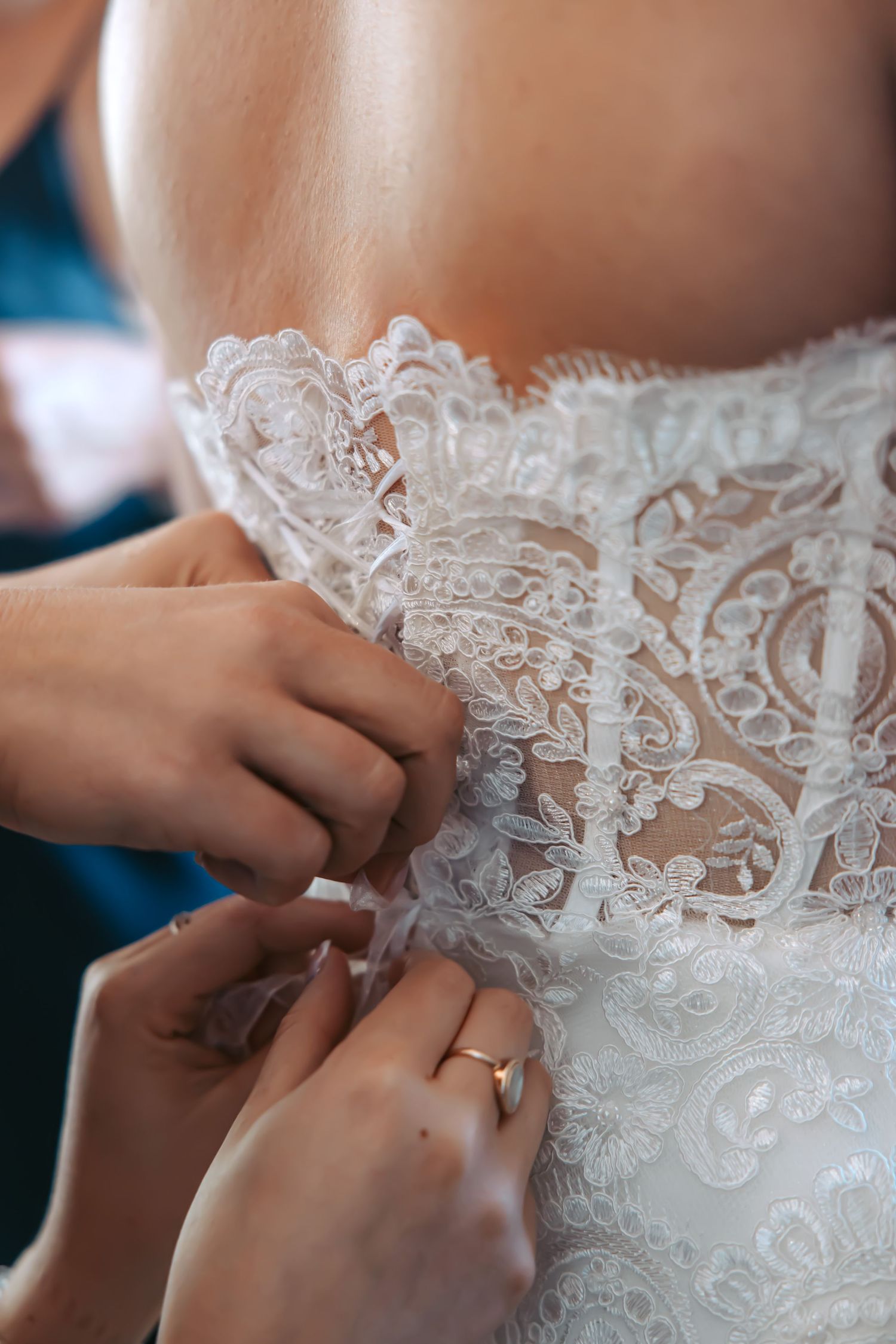 Close-up details of intricate lace buttons on back of wedding dress.