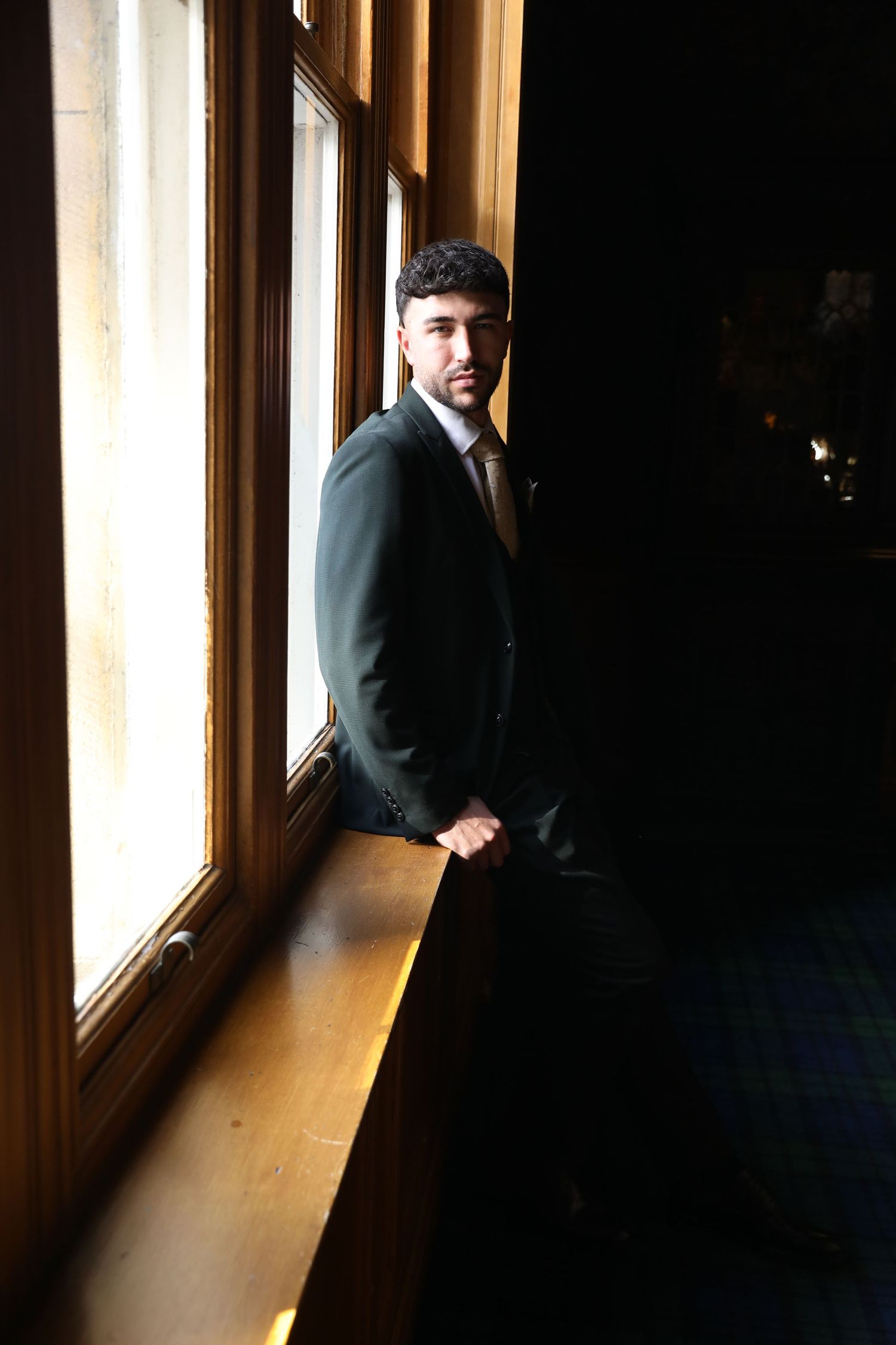 A dramatic series of photos showing a person in a dark suit standing in a hallway with sunlight streaming through windows.