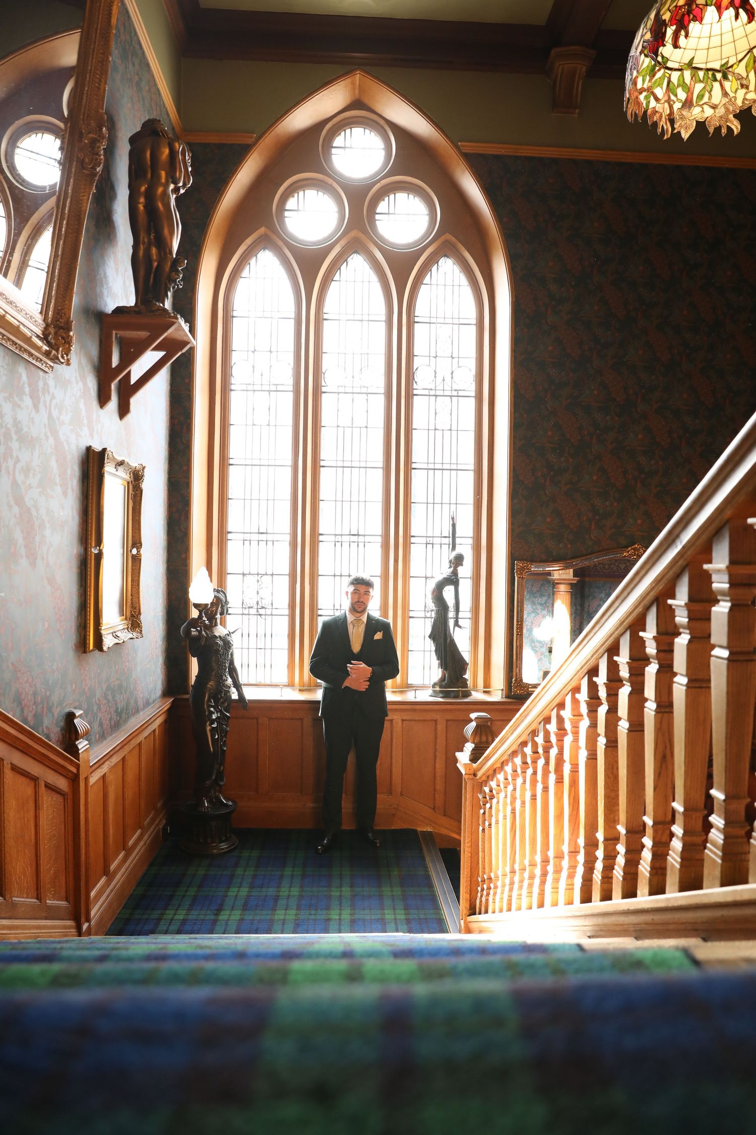 A sequence of five photos showing a person walking down a grand staircase in a church or historic building with arched windows.
