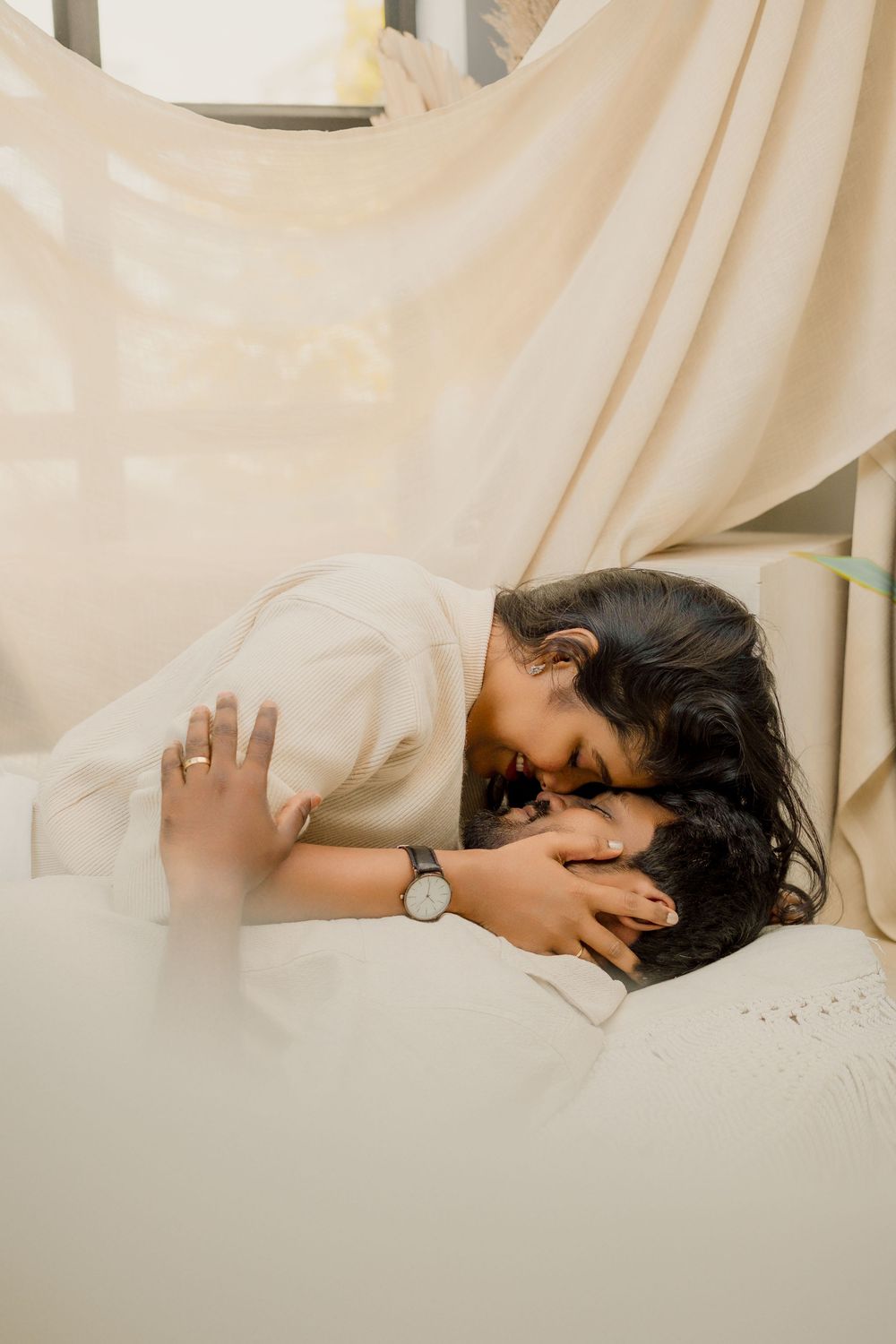 Artistic photo series showing intimate moments between a couple against white fabric backdrop.
