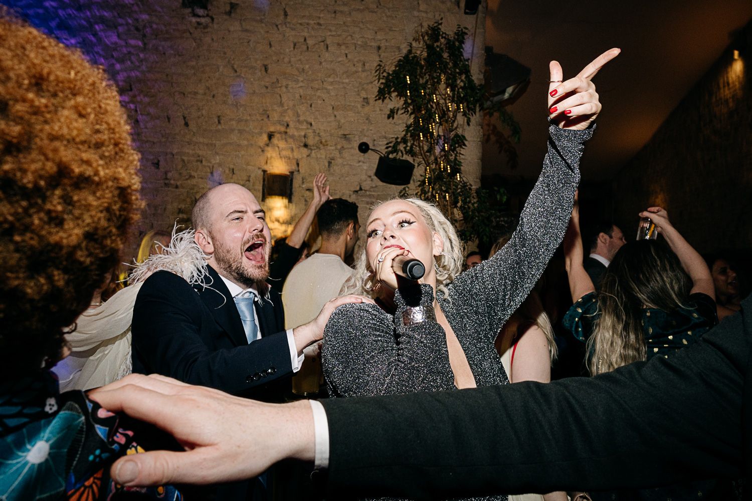 People dancing and celebrating at a lively party with energetic movements on a dance floor.