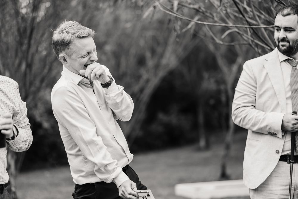 candid photos of guest laughing at the Waterside Country Barn and Mill wedding lakeside venue near Taunton, Somerset .