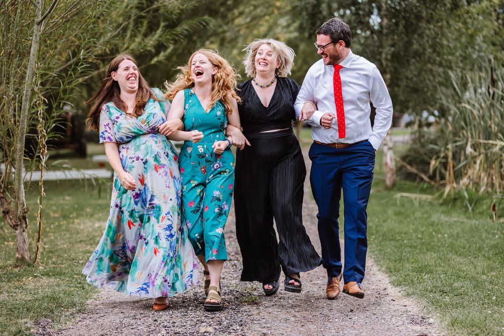 candid photos of guest laughing at the Waterside Country Barn and Mill wedding lakeside venue near Taunton, Somerset .