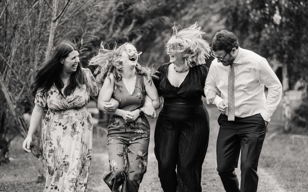 candid photos of guest laughing at the Waterside Country Barn and Mill wedding lakeside venue near Taunton, Somerset .