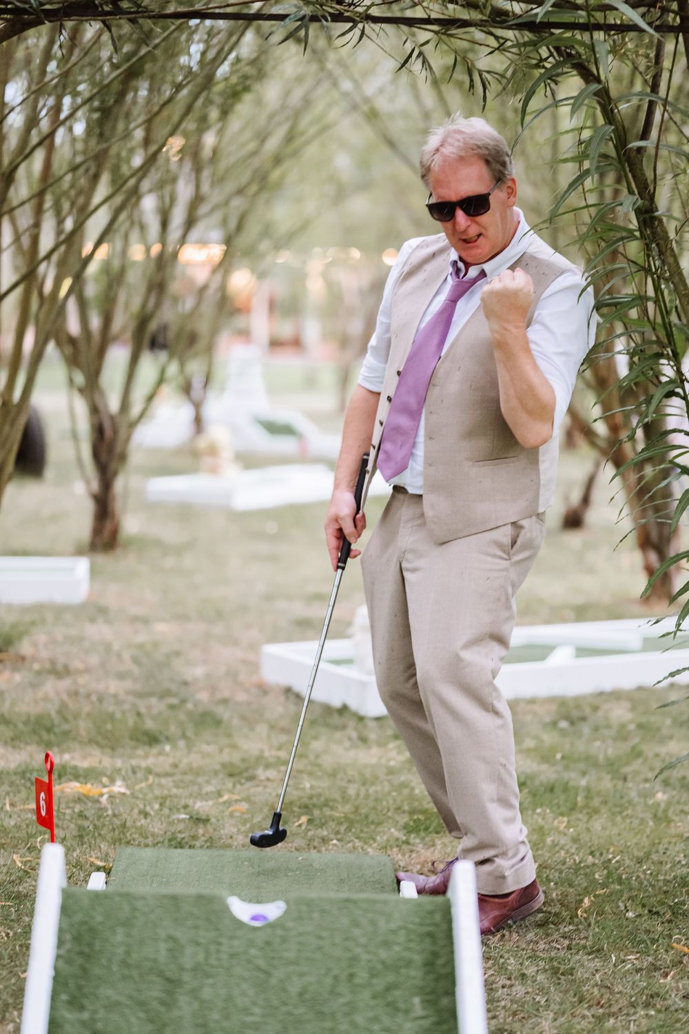 Bride and Groom play golf at their wedding at the  Waterside Country barn and mill lakeside wedding venue, Taunton, somerset. Relaxed