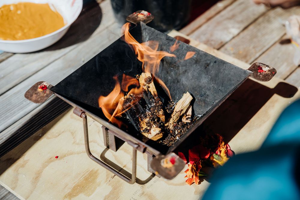 Close-up shot of burning incense or ceremonial items on a wooden surface.