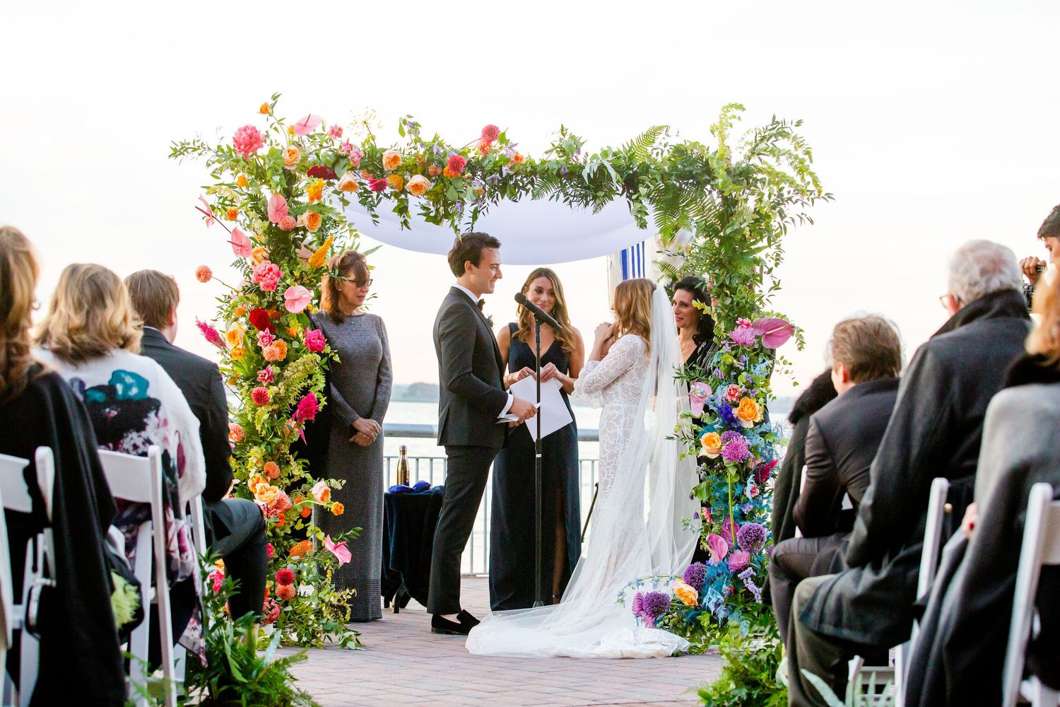 Wedding ceremony setup with colorful floral arrangements and seated guests.
