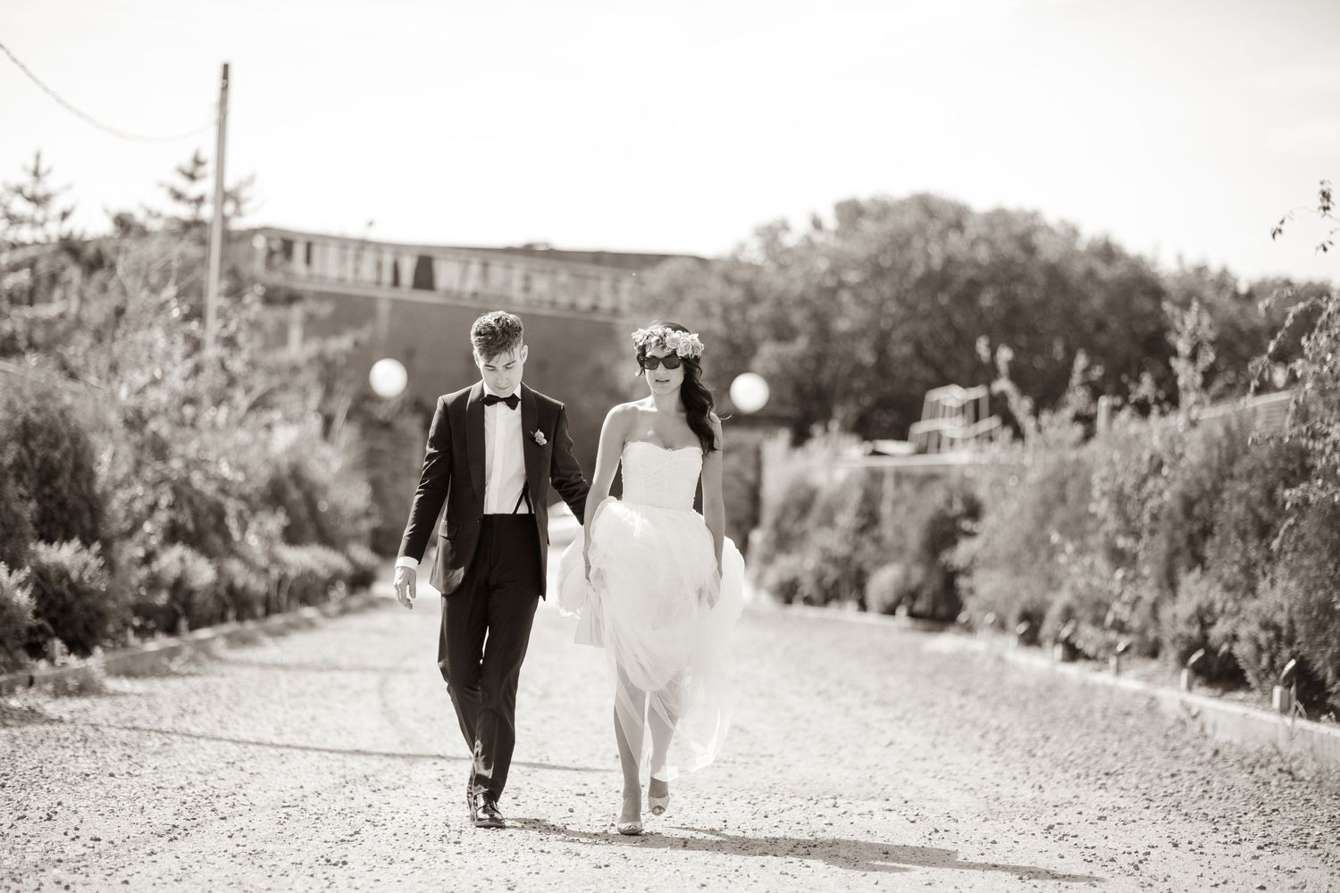Black and white photo series showing a couple walking along outdoor paths in formal wedding attire.