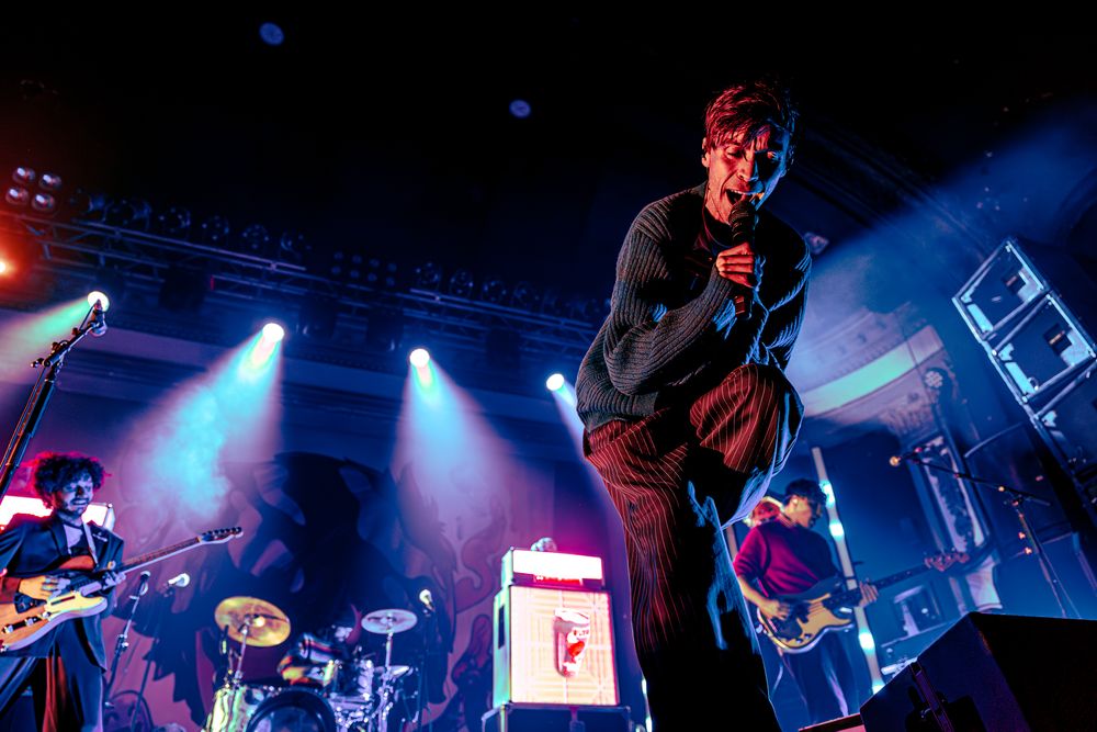 Concert stage illuminated with blue and red lights during a live performance at a music venue.