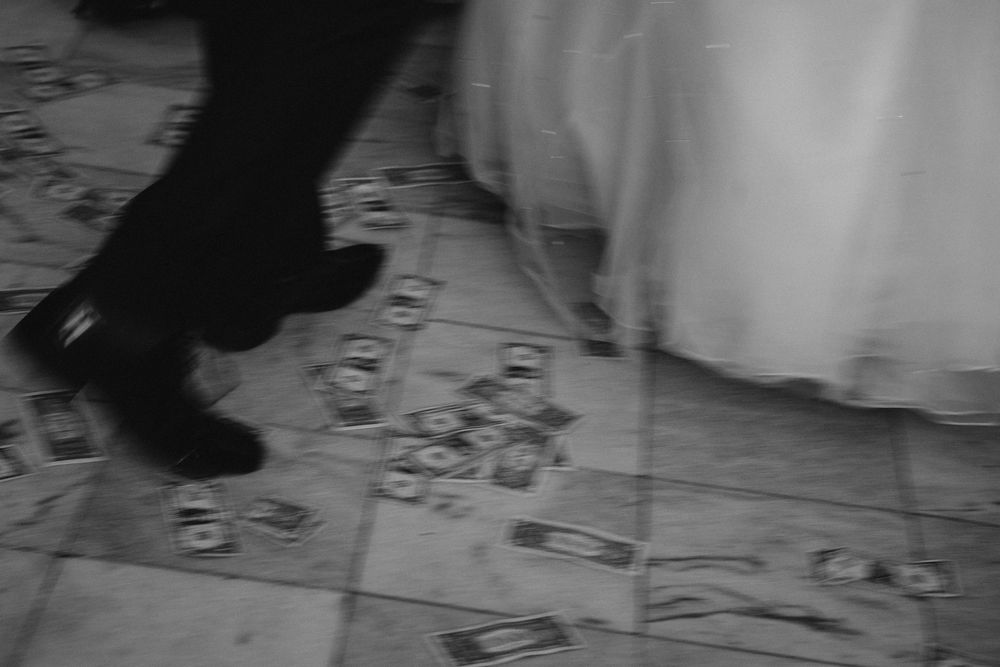 A black and white photograph shows people dancing together at a formal event on a dance floor.