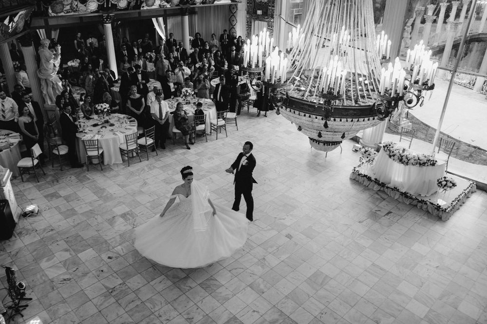 Panoramic view of an elegant wedding reception venue with chandeliers and decorative details.