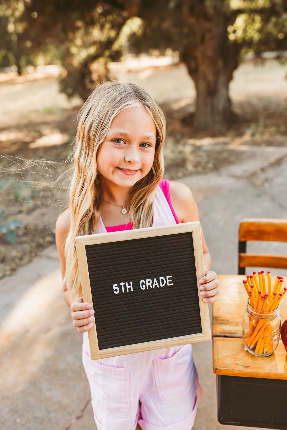 A series of back-to-school photos showing a student holding a letterboard displaying '5th Grade' in an outdoor setting.