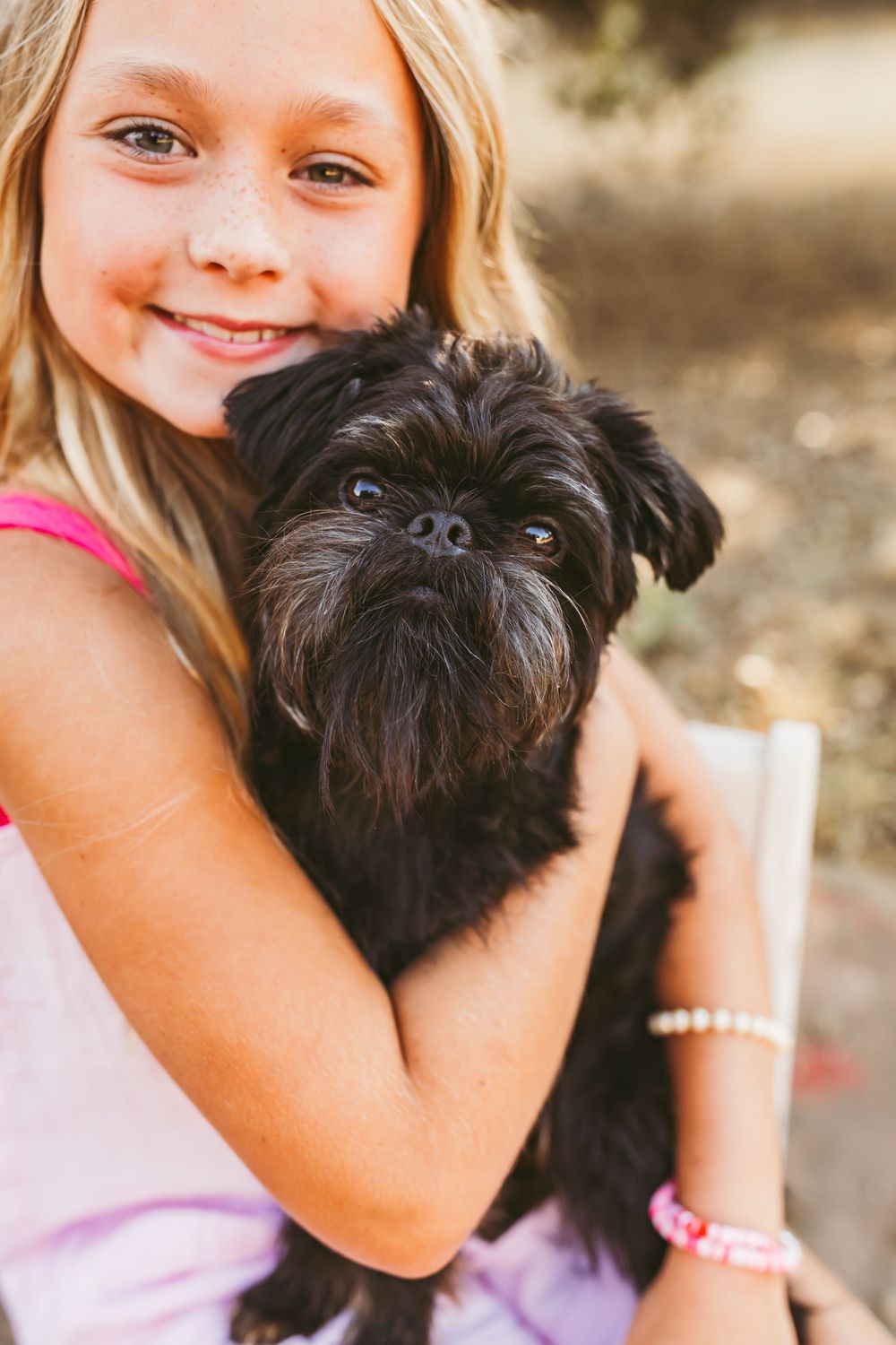 A black shih tzu dog being held and cuddled in a series of three photos.