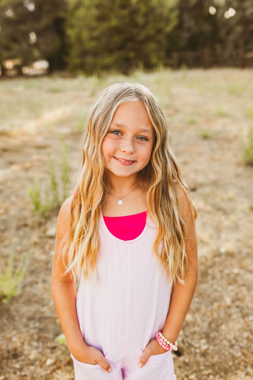 Outdoor portrait series showing a student in a white tank top posing against a natural background.