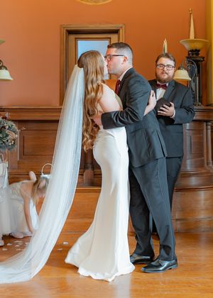 Wedding couple shares a romantic first dance sequence in a warm-lit ballroom.