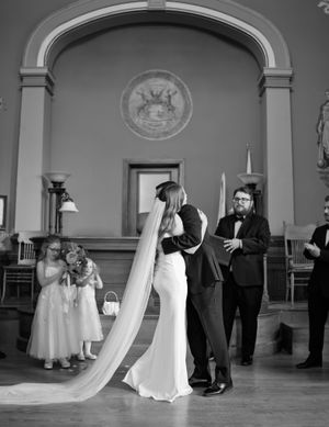 A series of black and white wedding photos showing a couple dancing in an elegant ballroom setting.