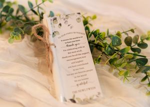 Wedding invitation details with delicate greenery and floral decorations on a light background.
