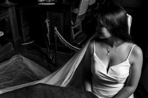 Dramatic black and white portrait of a bride in an elegant white dress.