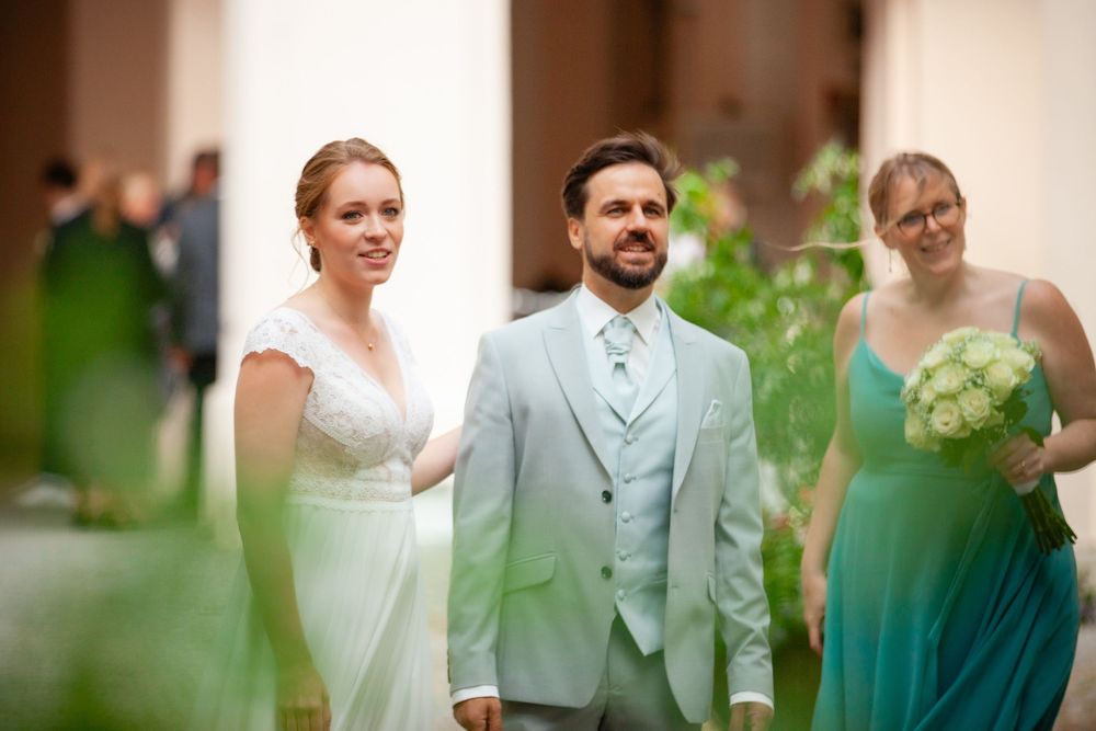 Wedding party wearing mint green and white attire gathered outdoors for celebration.