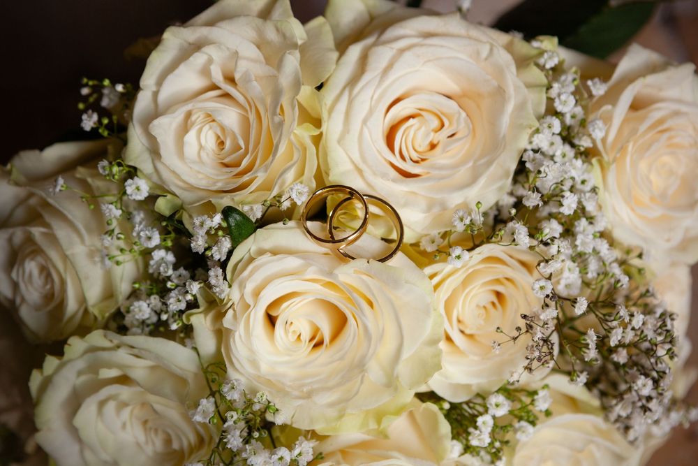Delicate cream colored roses and baby's breath arranged in an elegant wedding bouquet.