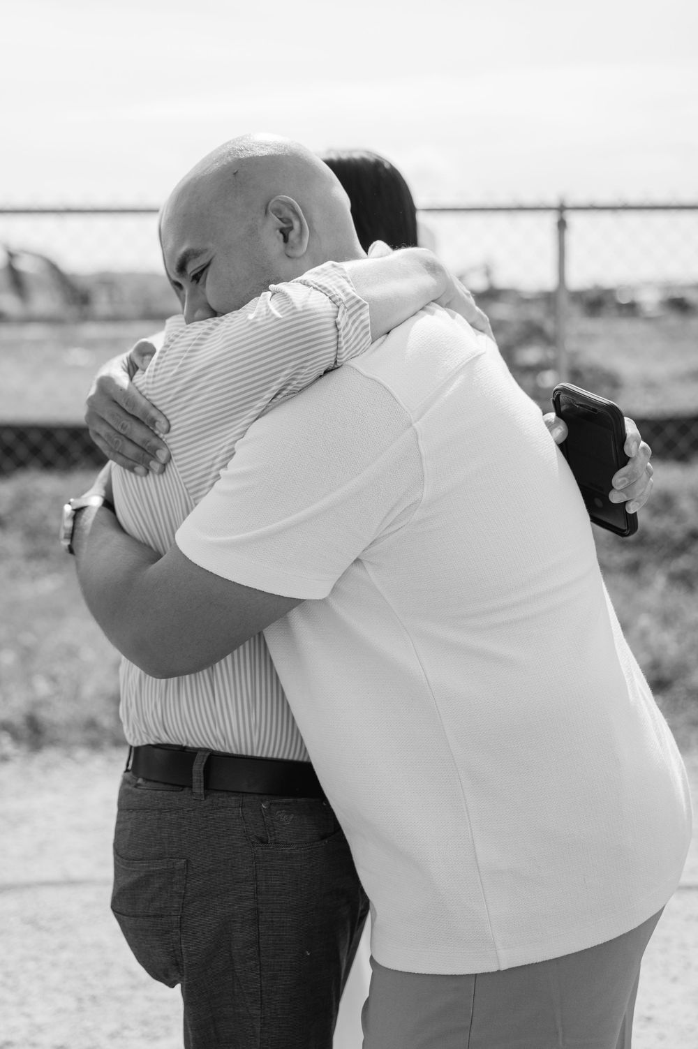 Black and white photos showing an emotional embrace between two people in formal attire.