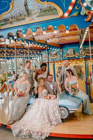 Wedding party poses on Anderson Pavilion carousel with flowers from @traceyrae_farmerflorist.