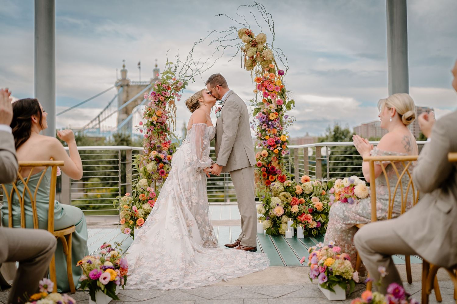 Bride and groom exchange vows during a waterfront ceremony at Anderson Pavilion in Cincinnati, captured by K Herman Photography.