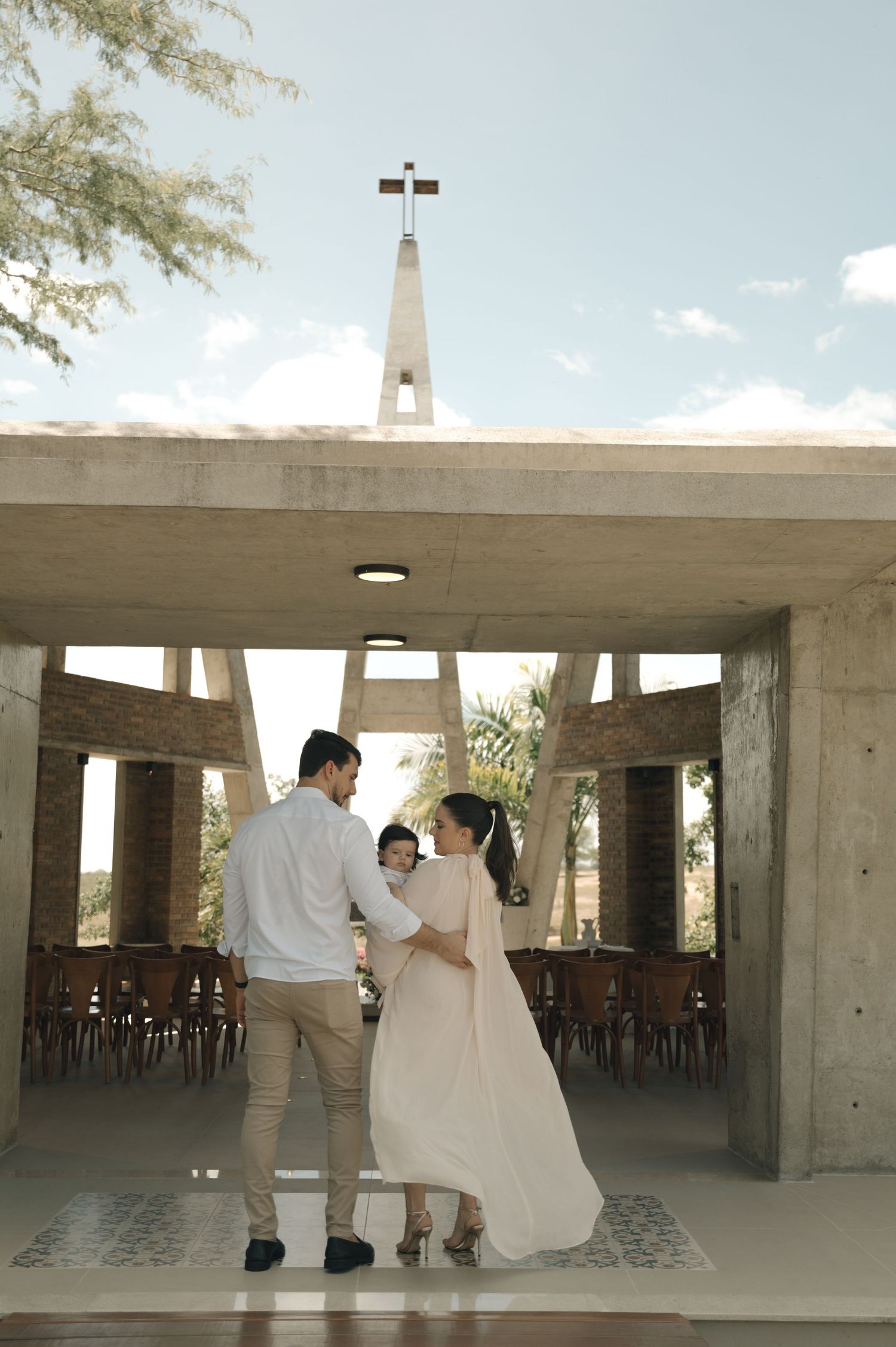 A couple in formal attire embraces in a church pew during a special occasion.