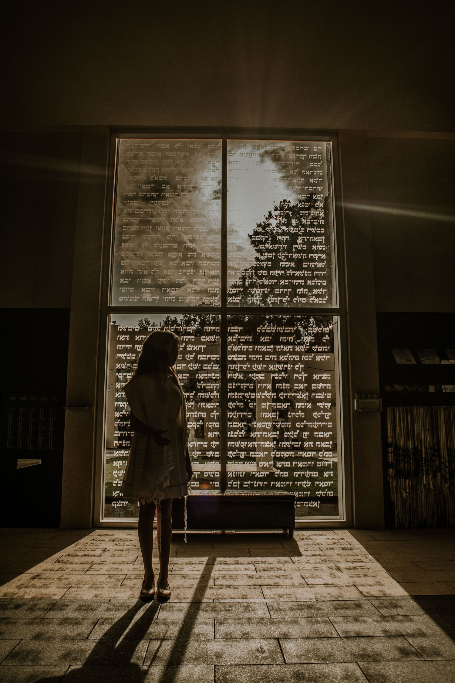 Girl standing in front of a large window at her Bat Mitzvah