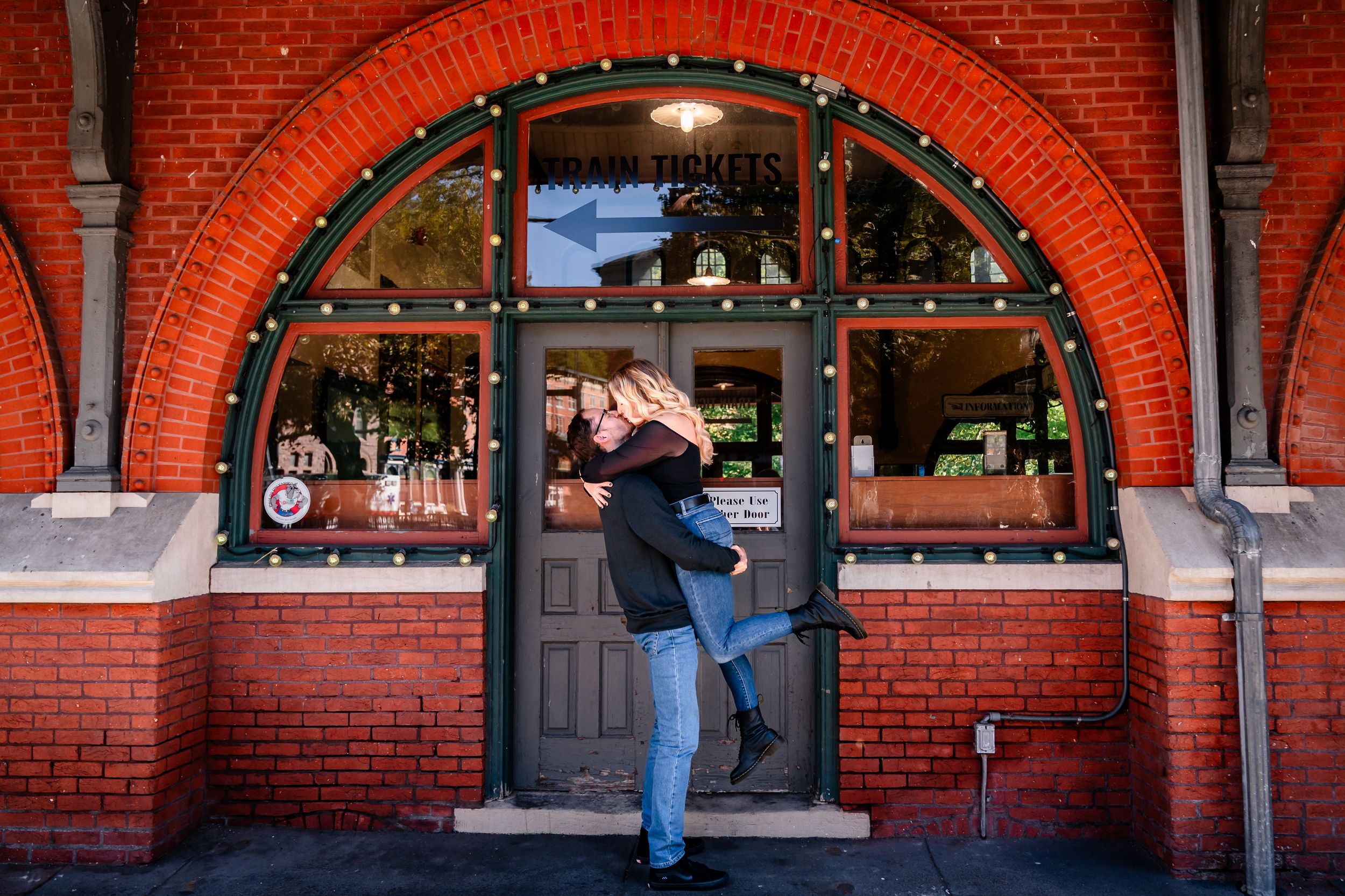 Historic red brick building facade with arched windows and decorative lighting.