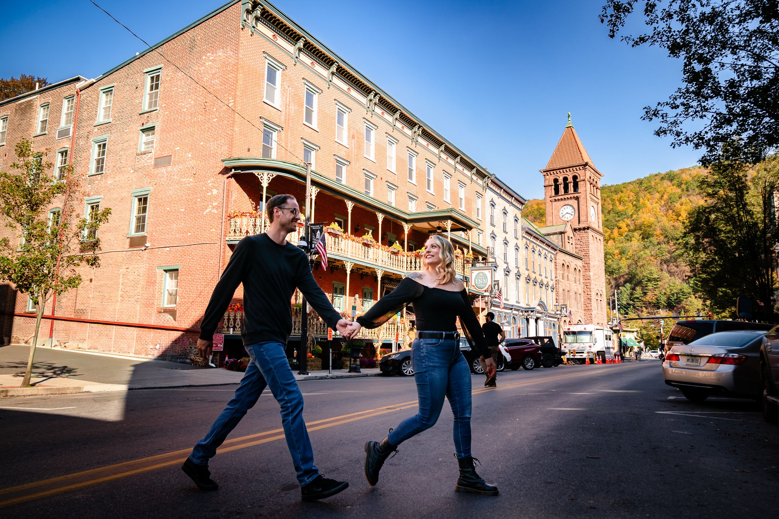 Historic brick buildings line a street under bright blue sky in autumn.