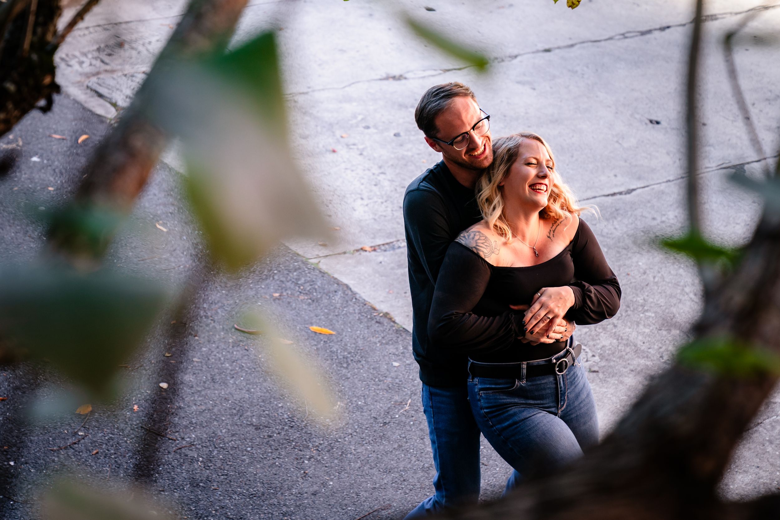 Intimate moment captured on urban sidewalk with artistic framing.