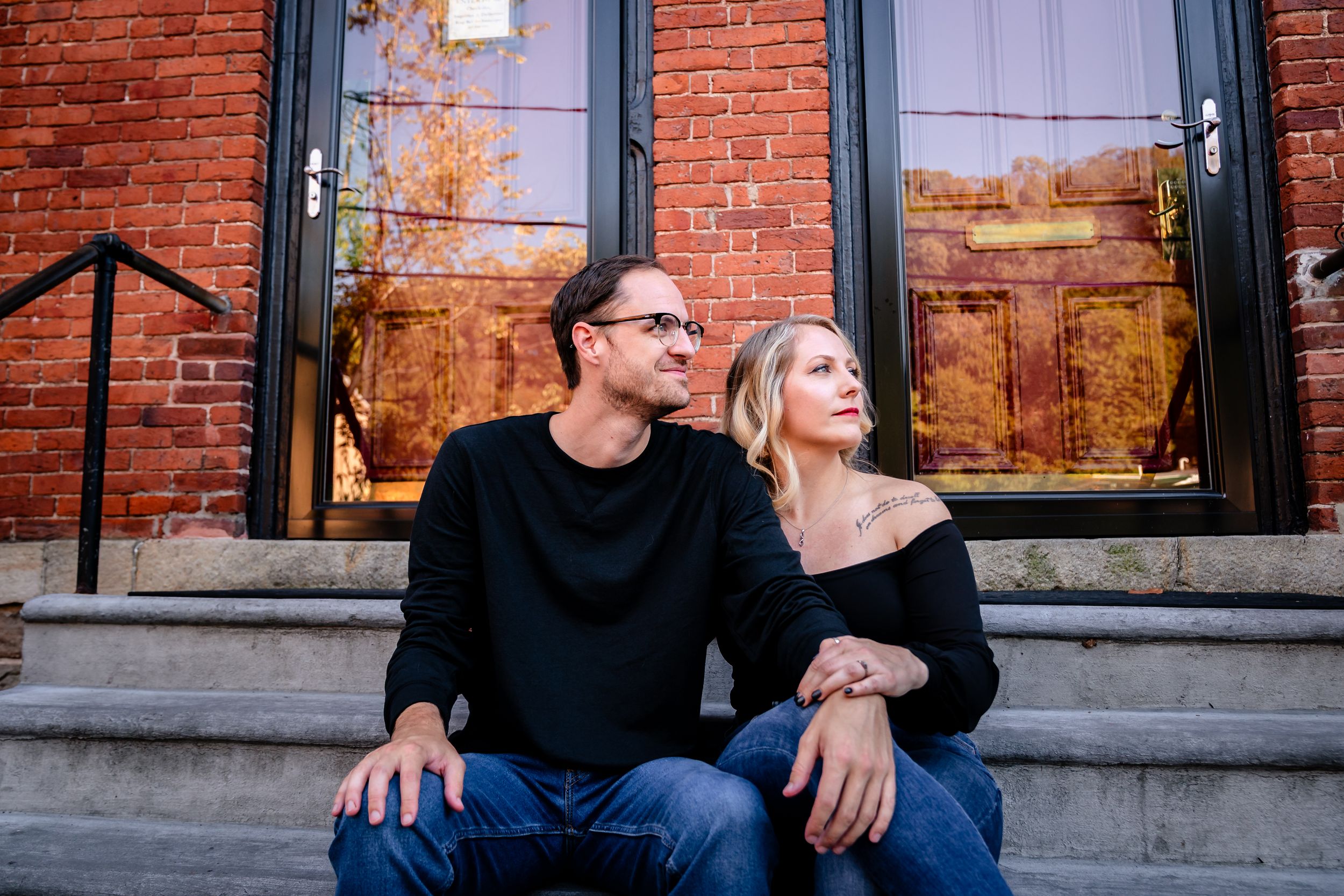 Couple relaxing on steps of historic brick building.