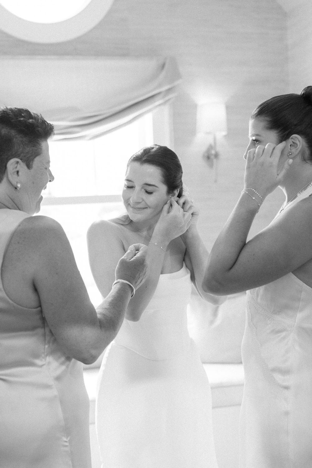 Black and white photo capturing emotional moment during wedding preparations.