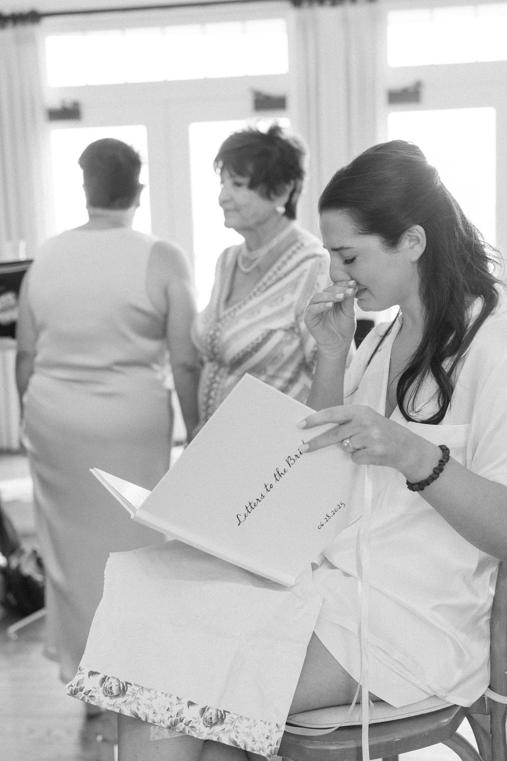 Wedding party members reading letters in a bright, sunlit room.