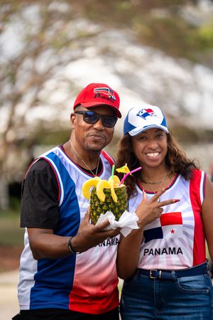 People wearing Panama sports jerseys and baseball caps posing at an outdoor event.