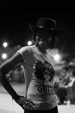 Black and white photo of performers in western attire at a nighttime event.