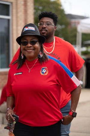 People wearing red Panama soccer team jerseys at an outdoor gathering.
