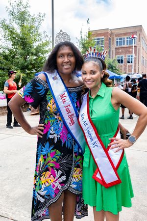Festival participants wearing colorful dresses and sashes at a community celebration.