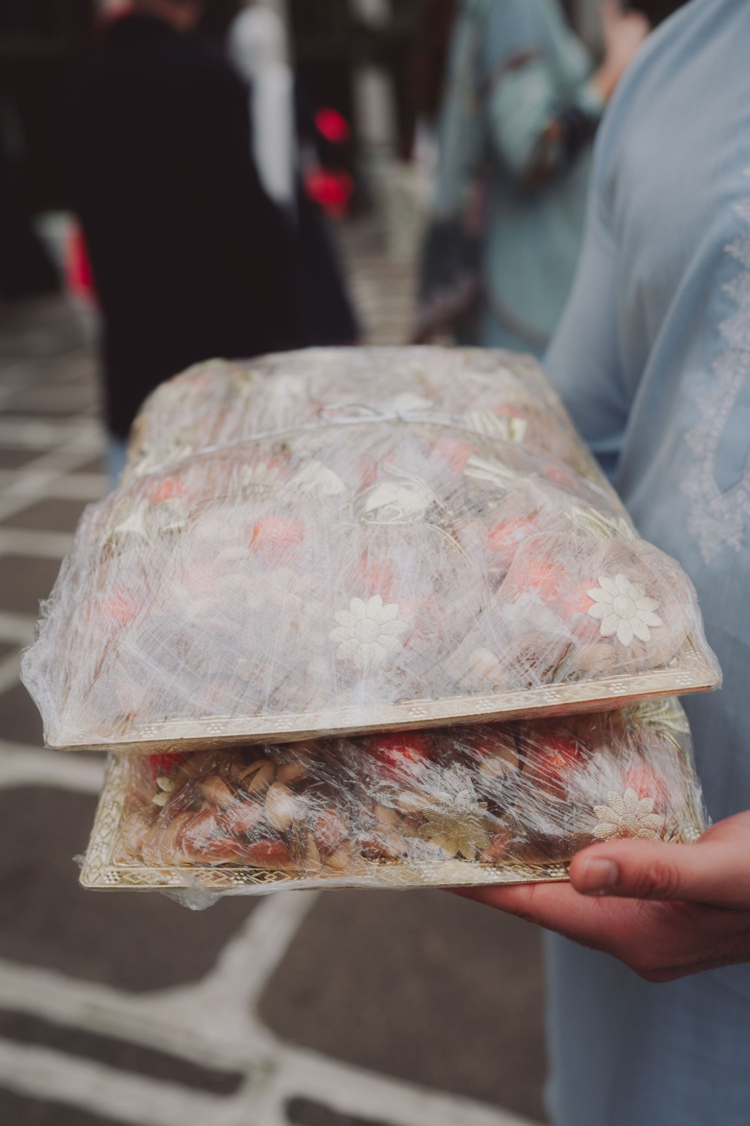 Close-up of hands holding traditional decorated paper wrapping or art piece.