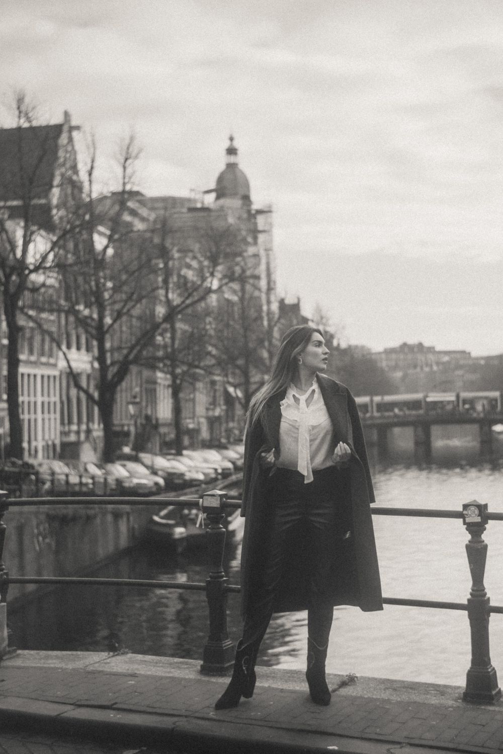 Black and white cityscape showing Amsterdam's iconic canal architecture and waterfront.