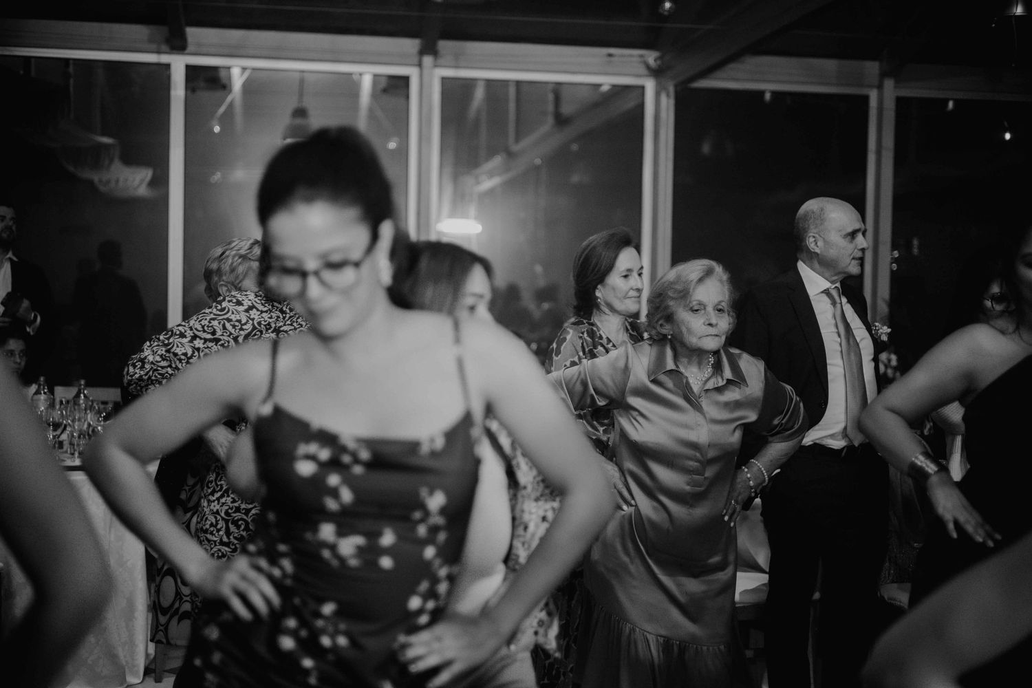 A crowd of dancers moves energetically in a dimly lit venue with dramatic lighting.