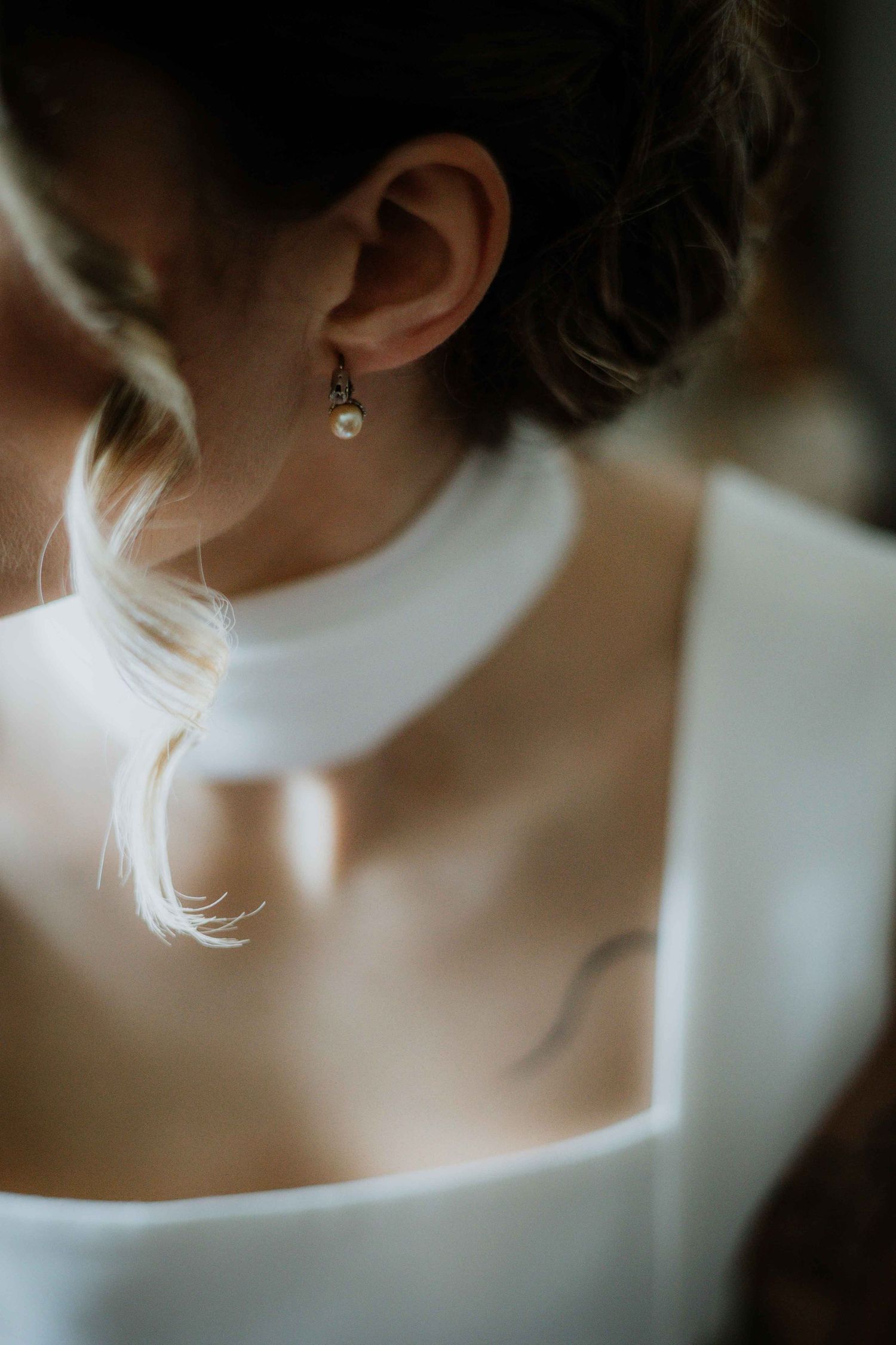 Elegant close-up of a white neckline and delicate jewelry in soft focus.