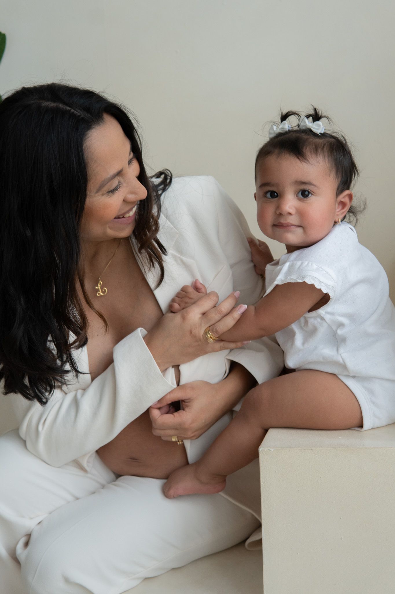 Pregnant women and a baby holding hands and smiling