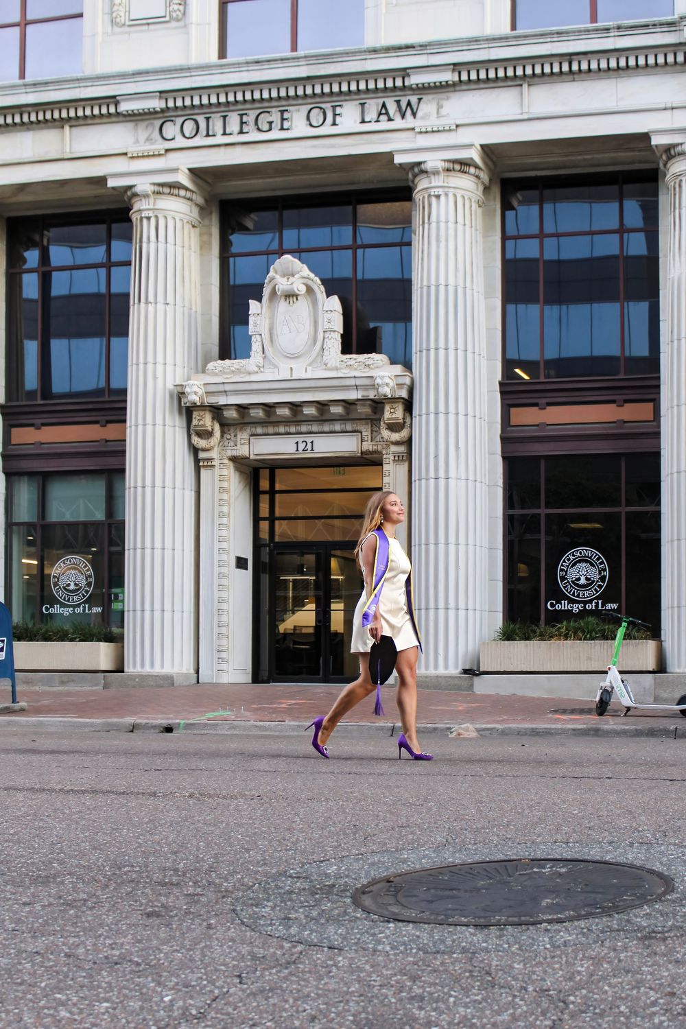 Students walking in front of a College of Law building with classical columns and architecture.
