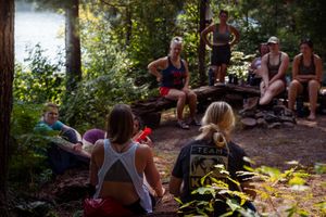 People take a break at a wooded rest stop during an outdoor activity on a sunny day in the forest.