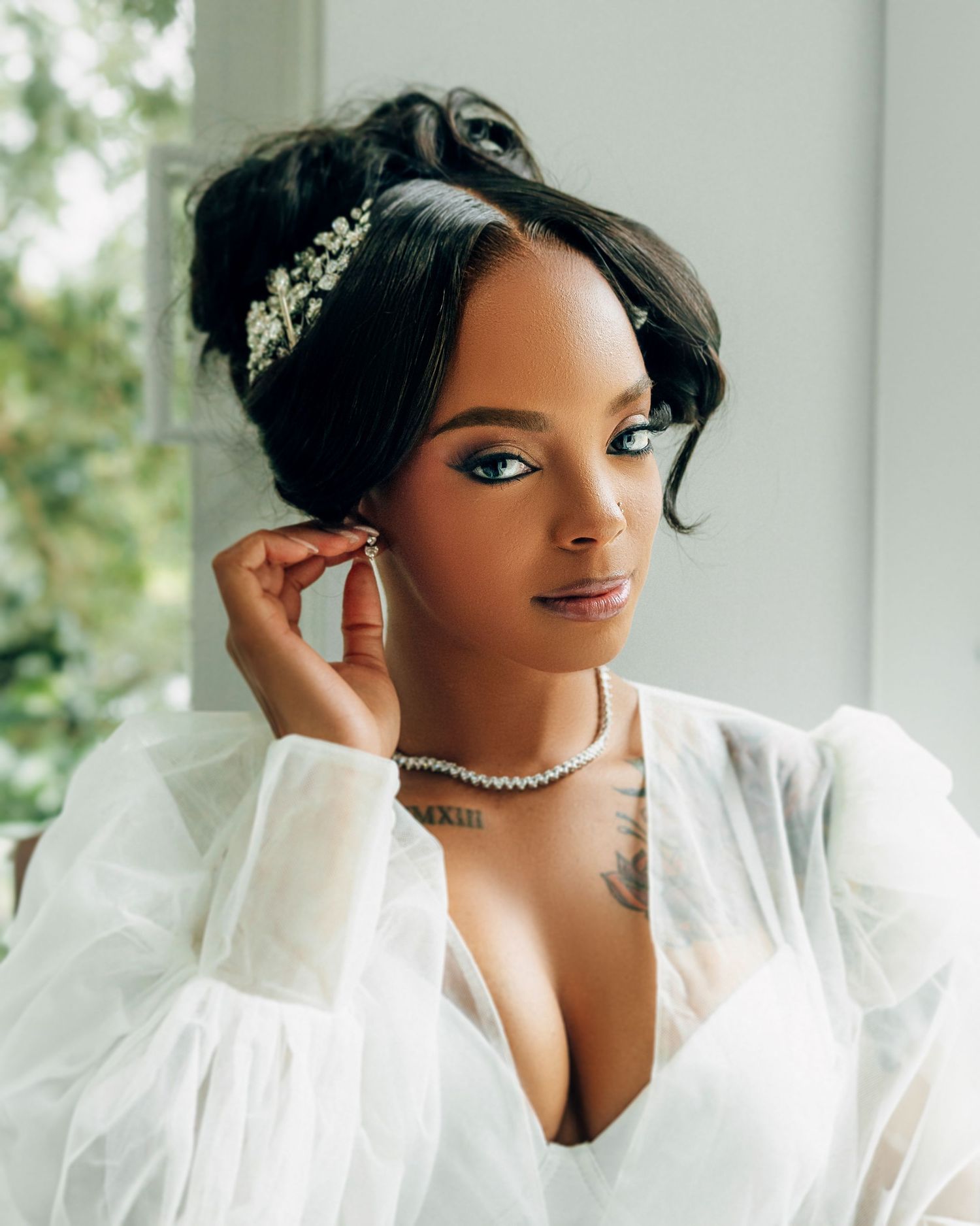 Bridal portrait featuring elegant hair accessory, pearl necklace and white robe.