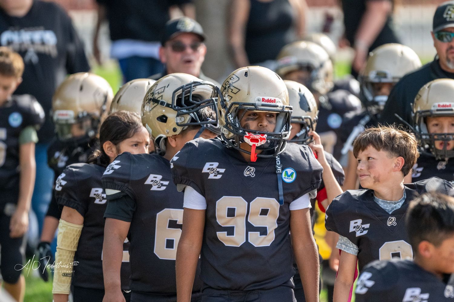 Football players in navy blue uniforms lined up on field during game day.