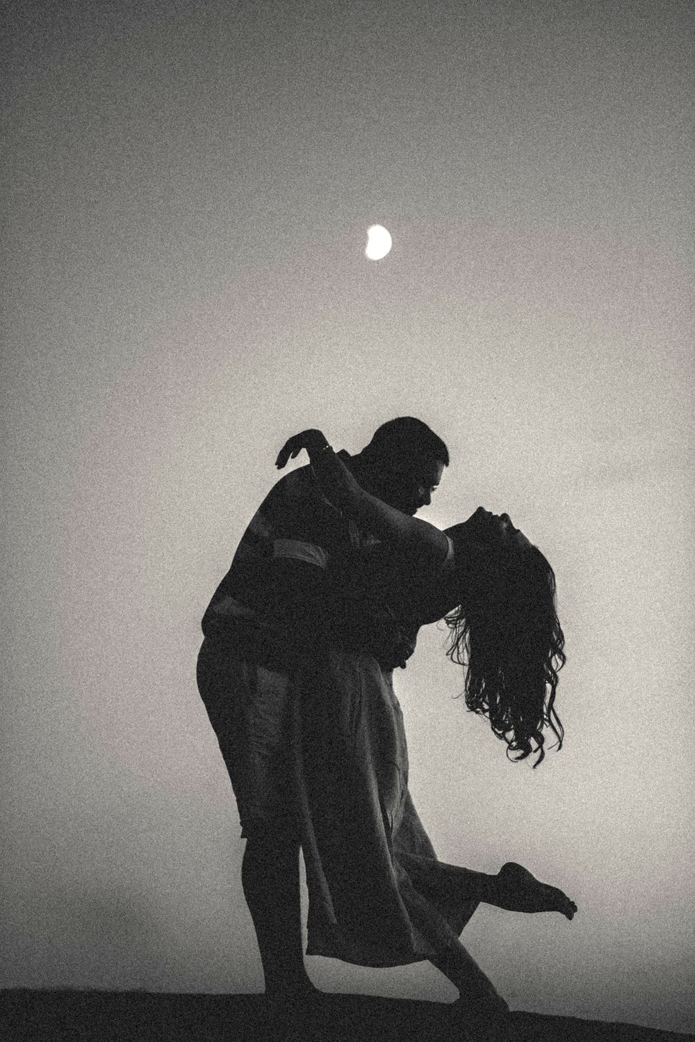Dramatic black and white dance duet silhouettes against minimalist background.