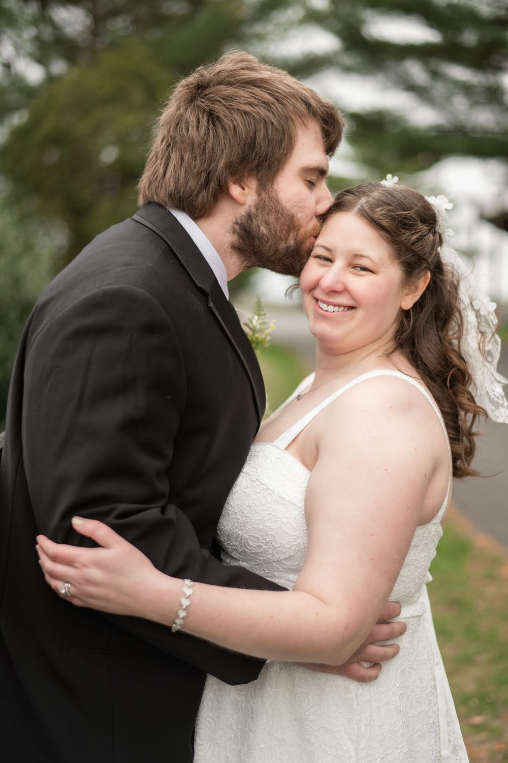 A tender moment between newlyweds as they embrace during their outdoor wedding ceremony.